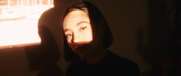 Shot of young woman in frame of movie screened by vintage projector