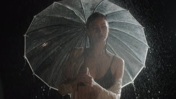 Hot Young Woman Standing Under the Rain and Twirls with an Umbrella