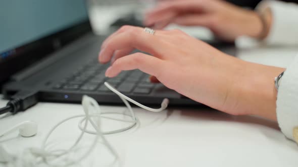 Female person typing on laptop keyboard in office closeup. Unrecognizable woman press on notebook