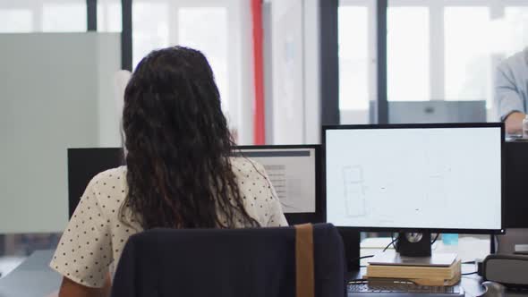 Woman passing a document to her colleague at office