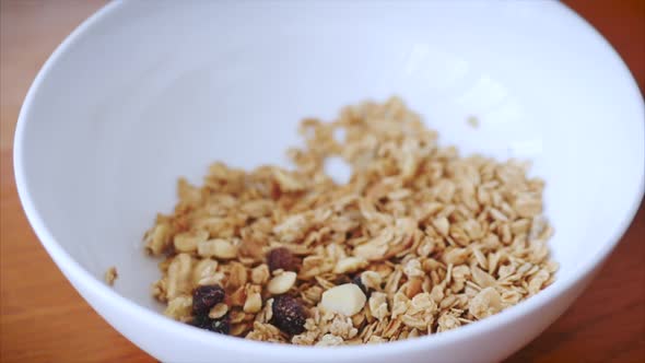 Slow Motion of Cereal Flakes Falling Into a Breakfast Plate. The Concept of Breakfast, a Healthy