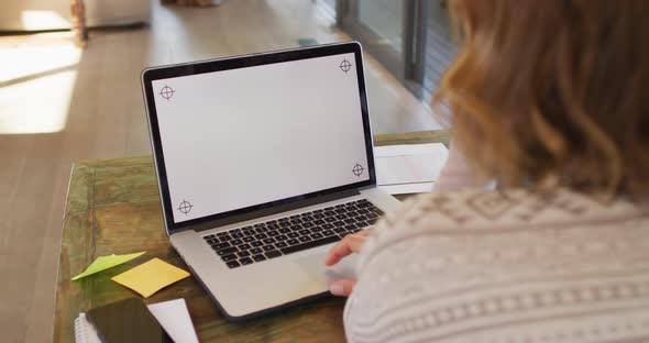 Back view of caucasian pregnant woman working remotely using laptop with copy space