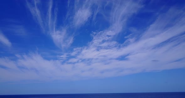 Luxury drone tourism shot of a paradise sunny white sand beach and blue ocean background in vibrant 