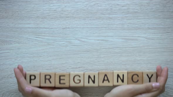 Pregnancy Hands Pushing Word on Wooden Cubes, Family Planning and Children