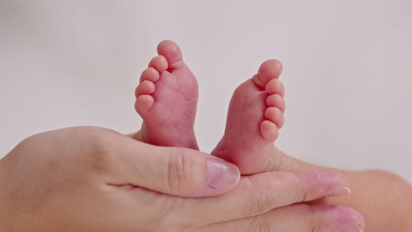 Close up Hand of Mother holding baby newborn foot with love
