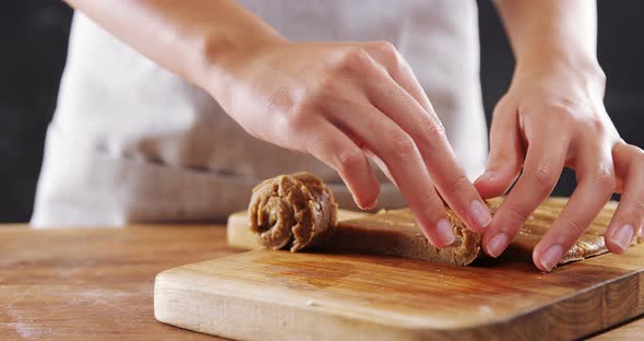 Woman rolling dough on chopping board 4k