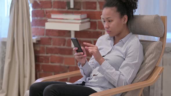 Attractive African American Woman Using Smartphone at Home