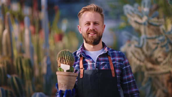 Enthusiastic Man Gardener Holding a Cute Cactus in