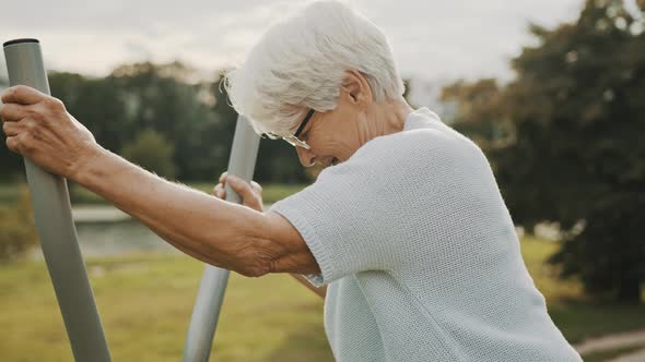 Old Woman Exercising in and Outdoor Gym, Slow Motion