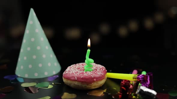 Party. Pink Donut and a Red Festive Candle on It. Golden Confetti Fall