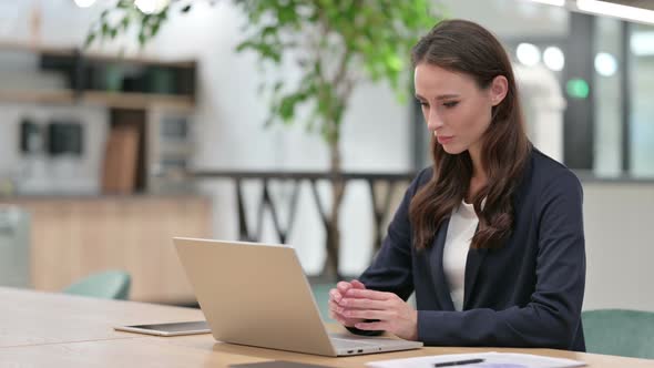 Businesswoman with Laptop Thinking at Work 