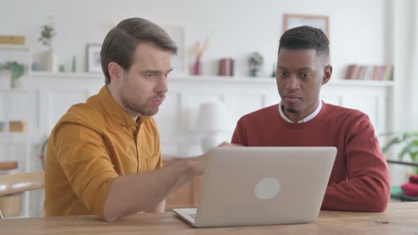 African Man and Young Man Working on Laptop