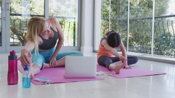 Mother and daughter performing stretching exercise at home