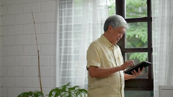 Portrait Asian senior man using tablet searching online shopping.