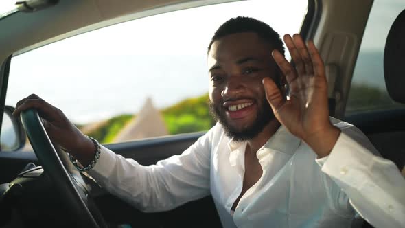 Portrait of Smiling Happy African American Gay Man Waving Looking at Camera Sitting in Right Hand