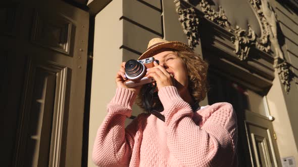 Woman Tourist Taking Photos With Vintage Camera While Sightseeing In City