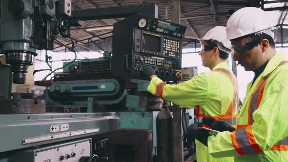 Group of Factory Workers Using Machine Equipment in Factory Workshop