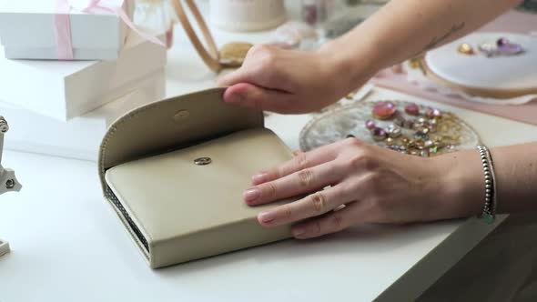 Designer woman sits at a work desk and works, opens a toolbox