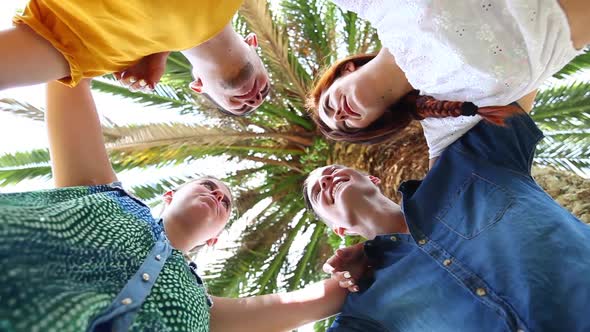 Group of teenagers embraced in circle, bottom view