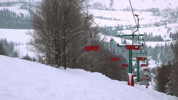 View of the Ski Lift Against the Background of a Mountain Forest and Gray Sky in the Carpathians