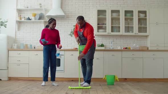 African Daughter Helping Single Father Mopping Floor