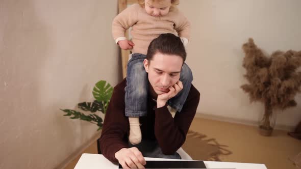 A Man Tries to Work Behind a Laptop at Home