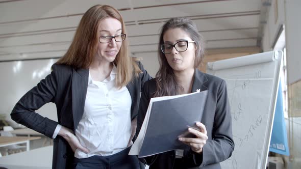 Focused Businesswomen Working with Papers