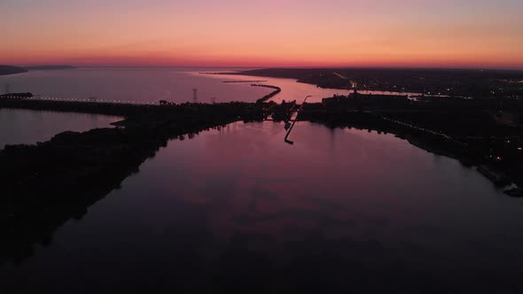 Aerial View. Sunset Over the Water Channel. In the Frame, a Dam or Bridge Is Strong. The Dam Covers