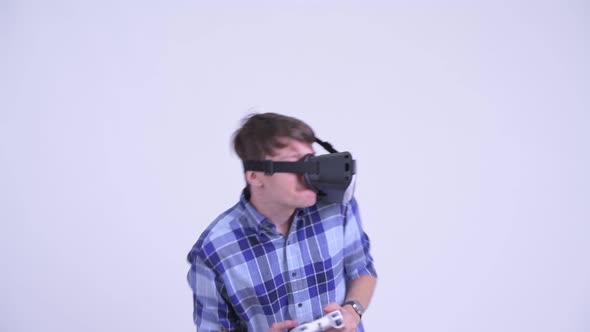 Happy Young Hipster Man Playing Games with Virtual Reality Headset