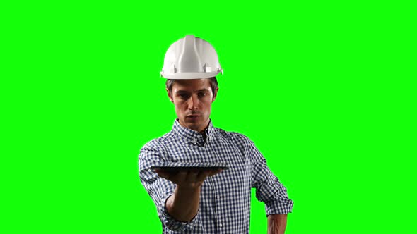 Front view of site worker holding a digital tablet with green screen