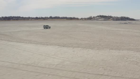 Four-wheel Drive Vehicle Driving At Makgadikgadi Towards The Famous Kubu Island (Ga'nnyo) In Botswan