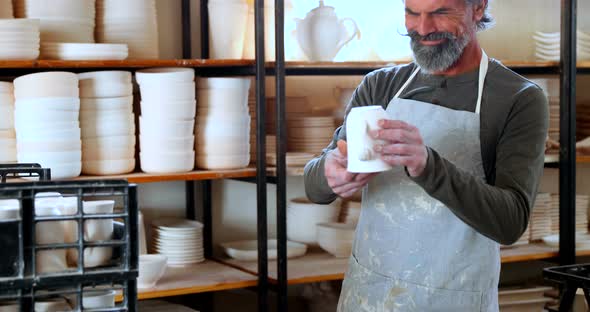 Male potter checking ceramic bowl 