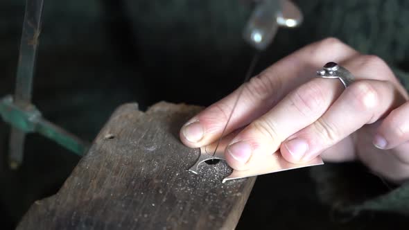 Cutting metal piece precisely with a fret saw at a workshop, Close up shot