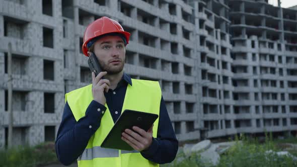 Man Stands and Discusses His House Project