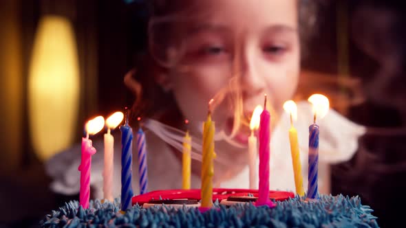 Child Blowing Out Candles on Cake