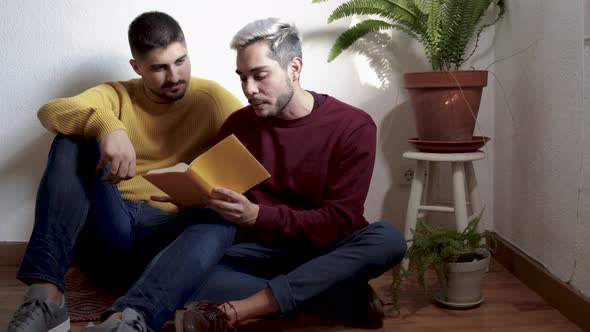 Lgbt Gay Couple Hugging and Reading Book Together Indoor at Home