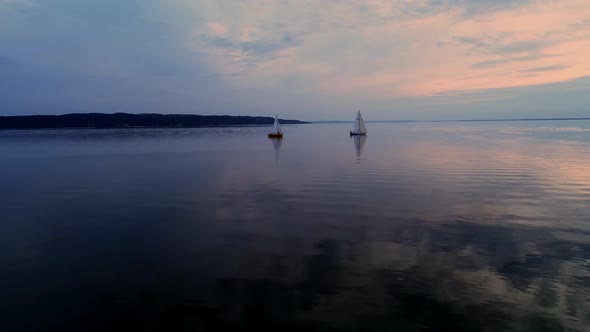 Aerial Drone Footage of Peaceful Scene with Yachts Cruising at Calm Water at Dusk