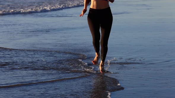 Slow motion shot of an Asian woman jogging on the beach