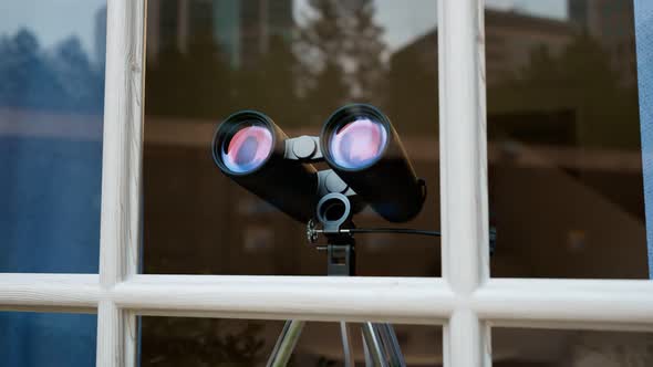 Binoculars in a window. Spying technology. Spy gear. Observation equipment.