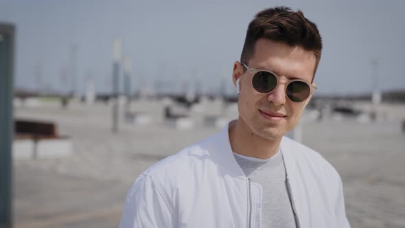 Portrait of a Stylish Man in Sunglasses and a White Jacket