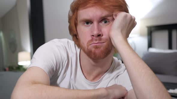 Thumbs Down By Casually Sitting Redhead Man Close Up