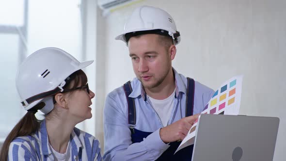 Portrait of Professional Workers Man and Woman in Protective Helmets and Color Sample in Their Hands