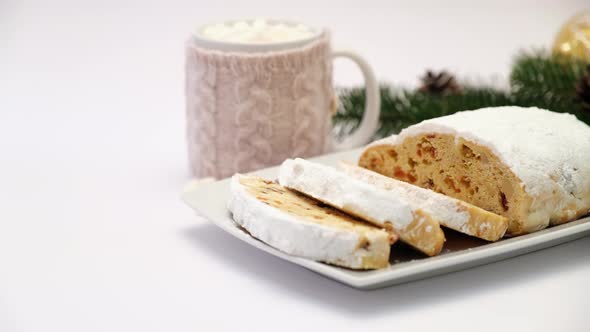 Sliced Traditional Christmas Stollen Cake on Ceramic Plate and Cup of Cocoa and Marshmallow