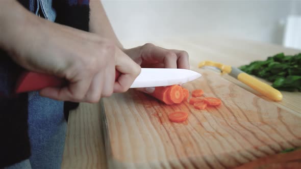 Woman cleaning and cutting carrots