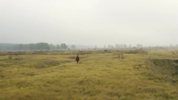 Documentarist standing in a foggy moorland, looking around, Czechia.