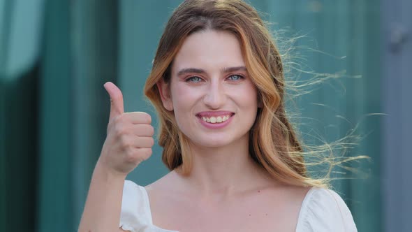 Young Satisfied Germanic Scandinavian Woman Smiling with White Teeth Showing Thumbs Up Looking at