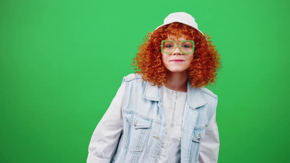 Cute Young Redhead Curly Lady Wearing Eyeglasses and Panama Hat Looking at Camera Enjoying Meeting