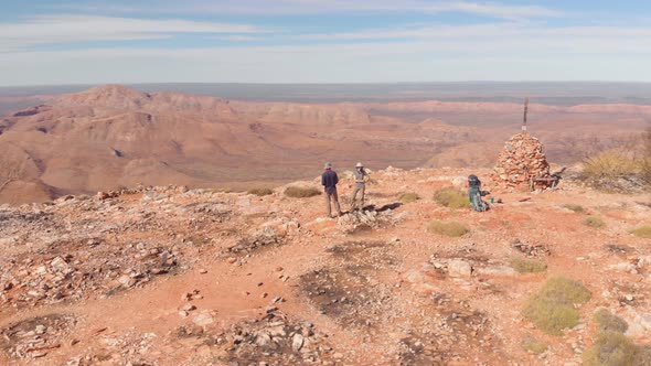 Aerial 360 arc, Hikers viewing mountain landscape from peak, Central Australia