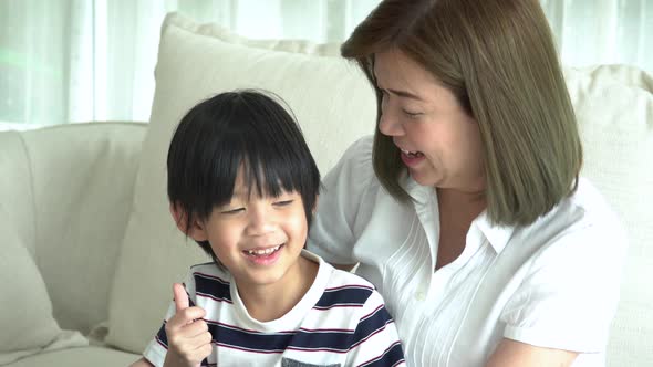 Asian Child And His Mother Talking Together