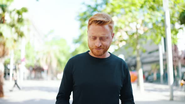 Worried red haired man walking and looking around